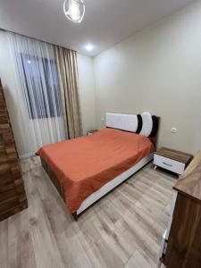 um quarto com uma cama com uma colcha laranja em MT House em Batumi