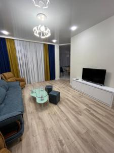 a living room with a couch and a flat screen tv at MT House in Batumi