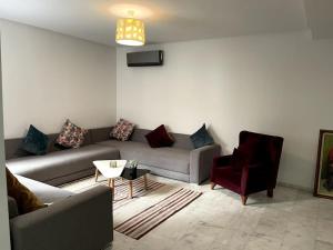 a living room with a couch and a chair at Magnifique duplex moderne à 1 minute à pied de la plage- Résidence Miramar Mohammedia in Mohammedia