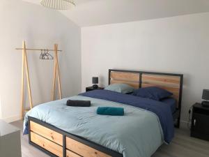 een slaapkamer met een groot bed met blauwe kussens erop bij Maison 8 personnes à 4 km de Bénodet in Gouesnach