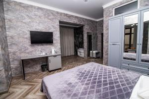 a bedroom with a bed and a tv on a wall at Hotel Black Sea in Sukhum