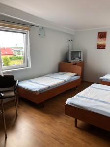 1 dormitorio con 2 camas y ventana en POD BOROWIKIEM, en Grzybowo