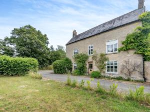 an old stone house with a driveway in front of it at The Glebe in Heckington