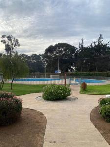 un parc avec une piscine et quelques buissons dans l'établissement Lomas Apart Papudo, à Papudo