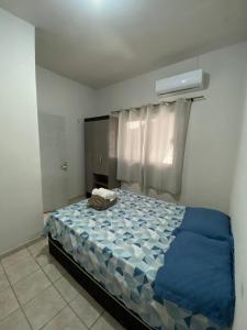 a bedroom with a bed with a blue comforter at Recanto Sonho - PX do Centro de Palmas e Aromaterapia in Palmas