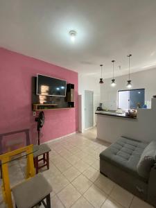 uma sala de estar com um sofá e uma parede rosa em Flats Recanto Sonho - PX do Centro de Palmas em Palmas