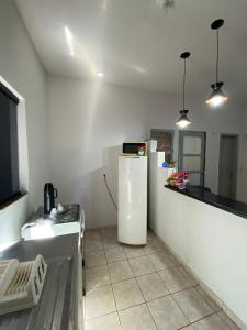 uma cozinha com um frigorífico branco e um balcão em Recanto Sonho - PX do Centro de Palmas e Aromaterapia em Palmas