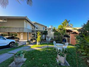 um quintal com duas cadeiras e uma mesa em frente a uma casa em MORADA ILHA PARAISO em Florianópolis