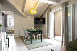 ein Esszimmer mit einem grünen Tisch und Stühlen in der Unterkunft Domus City Apartment in Argostoli