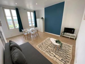 a living room with a couch and a table at La Perle Bleue in Dieppe
