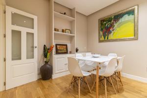 een eetkamer met een witte tafel en stoelen bij Allo Apartments Santo Domingo 2 Habitaciones - Parking in Jerez de la Frontera