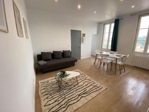 a living room with a couch and a table at La Perle Bleue in Dieppe