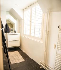 a bathroom with a window and a sink and a mirror at Kapiteinshuisje in Harderwijk