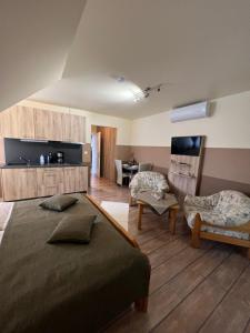 a bedroom with a large bed and a living room at Holler Vendégház in Bük