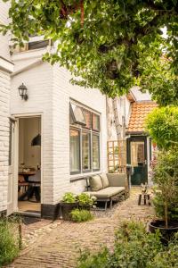 eine Terrasse vor einem Haus mit einer Couch in der Unterkunft Kapiteinshuisje in Harderwijk
