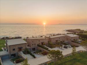 an aerial view of a sunset over the ocean at Real Life Homes luxurious seafront villas each with their own private pools in Korakokhórion