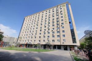 a large white building with a lot of windows at Your Home Away from Home in Almaty