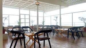 a restaurant with wooden tables and chairs and large windows at Onehouse Resort Lansdowne in Lansdowne