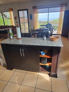 a kitchen with a counter and a dining room with a table at Villa Roberto Vista Hermosa in Sardinal