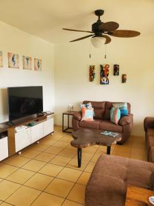 a living room with two couches and a flat screen tv at Villa Roberto Vista Hermosa in Sardinal