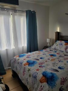 a bedroom with a bed with a comforter with birds on it at Villa Roberto Vista Hermosa in Sardinal