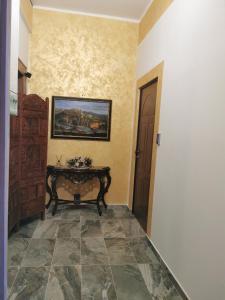 un couloir avec une table et un tableau sur le mur dans l'établissement L'Anfora, à Montesilvano