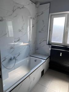 bagno bianco con vasca e finestra di Maurice en ville n14 a Namur