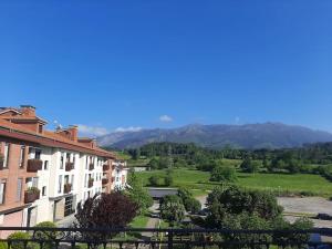 vistas a una ciudad con montañas en el fondo en Apartamento El Horrín ( Colunga ), en Colunga