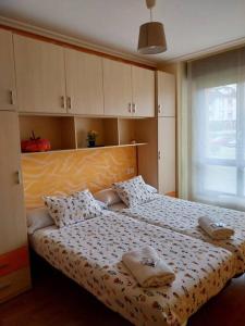 a bedroom with a bed with two towels on it at Apartamento El Horrín ( Colunga ) in Colunga