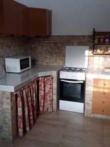 a kitchen with a stove and a microwave at Casa Vacanze Le Macchie in Parabita