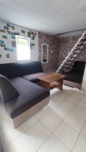 a living room with a couch and a staircase at T-Lak Vendégház Tiszalök in Tiszalök