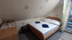 um pequeno quarto com uma cama com toalhas azuis em T-Lak Vendégház Tiszalök em Tiszalök