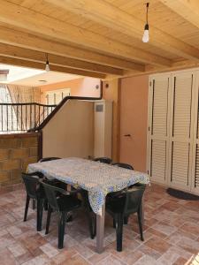 une salle à manger avec une table, des chaises et un escalier dans l'établissement Appartamento Vacanza Mare Gioiosa Marea Zappardino, à Gioiosa Marea