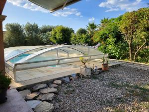 a glass house with a pool in a garden at La Toscane in Roquebrune-sur-Argens