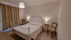 MonterubbianoにあるIl Piccolo Carro Apartmentsのベッドルーム1室(ベッド1台、椅子2脚、ランプ2つ付)