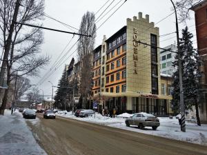 Una calle de la ciudad con coches aparcados en la nieve en Bogemia Hotel on Vavilov Street, en Saratov