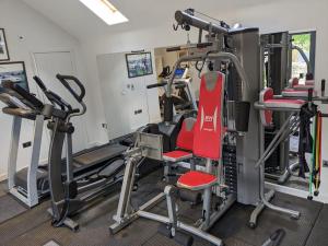 a gym with several tread machines and a red chair at Cottage in Matlock, Derbyshire. Lower Holly Barn in Matlock Bank