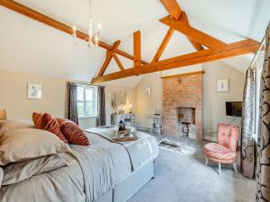 a bedroom with a large bed and a fireplace at Paddock Cottage in Scalford