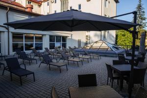 a patio with tables and chairs and an umbrella at LH Hotel&SPA in Lviv