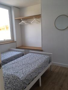 Cette chambre comprend 2 lits et un miroir. dans l'établissement LA MARINA, à Galizano