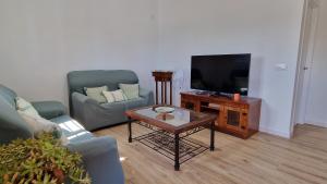 a living room with two chairs and a tv at Casa vacacional en Chiclana de la Frontera in Chiclana de la Frontera