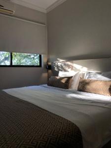 een slaapkamer met een groot wit bed met 2 kussens bij Iguassu Express Hotel in Foz do Iguaçu