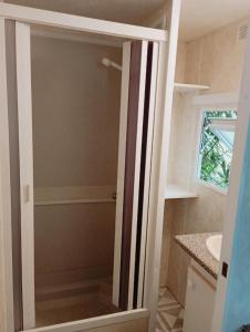 La salle de bains est pourvue d'une douche avec une porte en verre. dans l'établissement MOBIL HOME, à Faux-la-Montagne