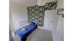 巴克斯頓的住宿－Torr Mews，一间设有蓝色床和墙壁的小卧室