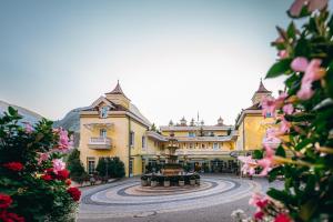 duży żółty budynek z fontanną przed nim w obiekcie Wellnessresidenz Alpenrose w mieście Maurach