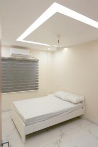 a white room with a bed and a window at IZEL CASA in Ernakulam