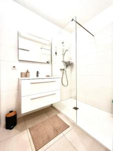 Un baño blanco con ducha y lavabo. en Appartement Terrasse St Florent, en Saint-Florent
