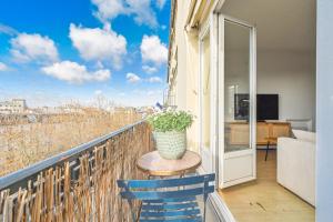 - un balcon avec une table et un vase de fleurs dans l'établissement Vue Tour Eiffel / Sacré-Coeur, à Paris