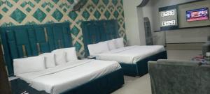 a hotel room with two beds and a tv at Hotel Grace inn in Multan