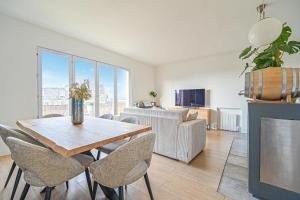 sala de estar con mesa, sillas y sofá en Vue Tour Eiffel / Sacré-Coeur, en París